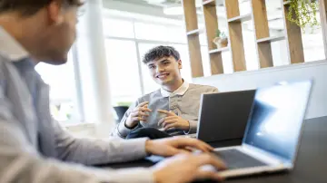 merkur-group-careers-students-conversation-laptop