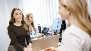 merkur-group-careers-working-students-conversation-laptop-desk
